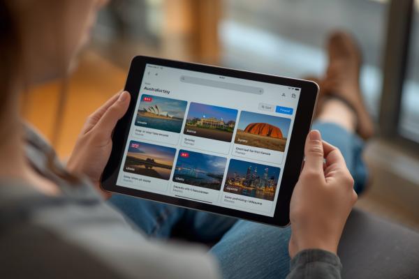 professional photo of Professional photo of traveller planning trip using AI assistant on tablet, AI powered search results showing Australian destinations like Sydney Opera House, Great Barrier Reef, Ulu (1)